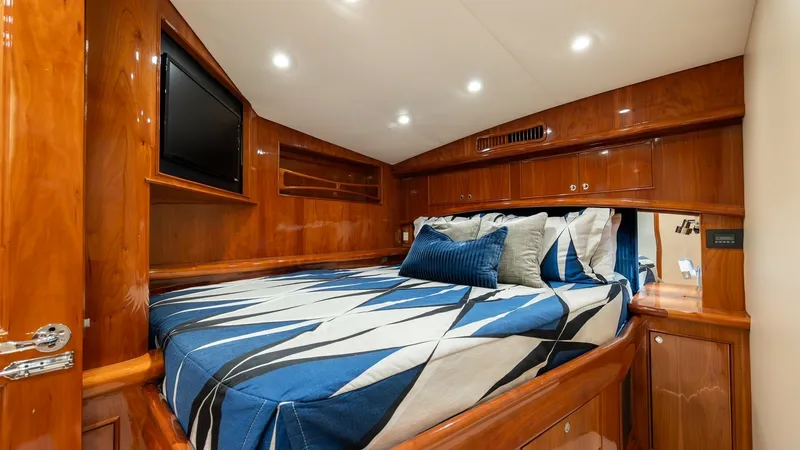 Slide: The Image of Luxurious Forward Stateroom This forward stateroom exudes elegance with its rich wood finishes and soft recessed lighting. The spacious berth is adorned with plush bedding, providing a cozy retreat. Ample storage options and a mounted TV enhance comfort and functionality, making it - 7961713