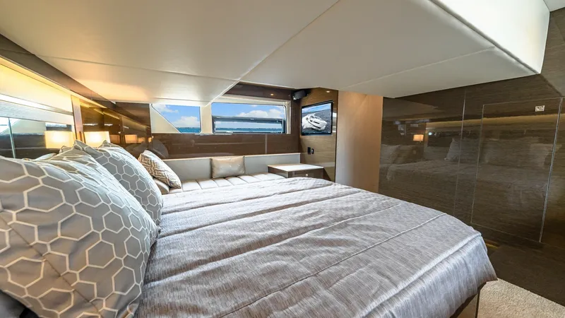 Slide: The Image of Luxurious Master Stateroom This master stateroom on the 2019 Cruisers Yachts Cantius 46 offers a spacious and elegant retreat. The room features a plush double bed with stylish bedding, surrounded by sleek wood finishes and ample natural light from large windows. Modern lighting an - 8141250
