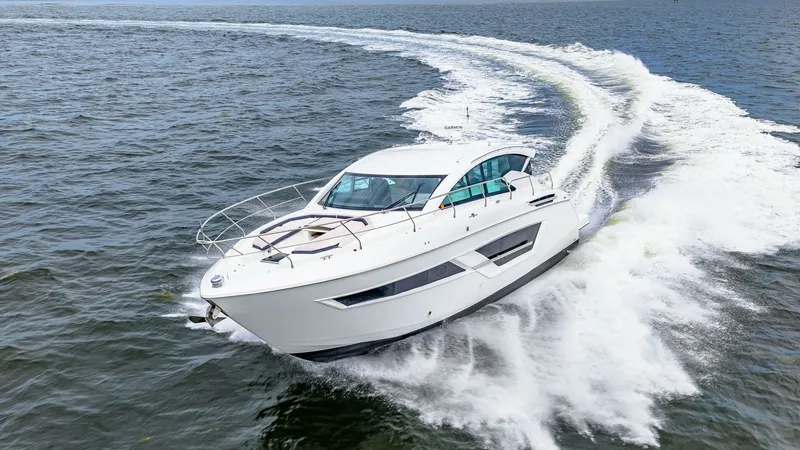 Slide: The Image of Dynamic Bow View in Motion The 2019 Cruisers Yachts Cantius 46, named Serenity, glides effortlessly through the water, showcasing its sleek bow design and modern lines. The vessel's aerodynamic shape and advanced hull construction allow for smooth navigation and impressive performa - 8141313