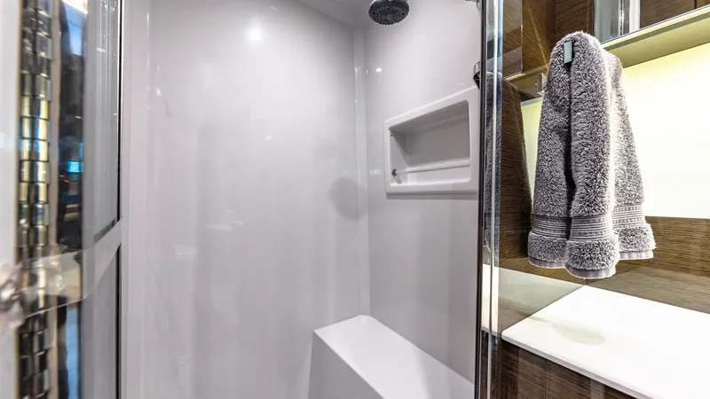 Slide: The Image of Spacious Enclosed Shower Cabin The enclosed shower on the Serenity features sleek, modern design with a built-in bench for added comfort. The high-gloss surfaces and stylish fixtures exude luxury, while ample lighting enhances the contemporary feel. This space is both functional and el - 8141254