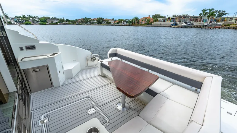Slide: The Image of Spacious Aft Deck with Seating The aft deck of the 2019 Serenity Cantius 46 offers a luxurious outdoor seating area with a stylish wooden table. The space features comfortable upholstered benches and sleek flooring, perfect for entertaining or relaxing with a waterfront view. Designed - 8141263