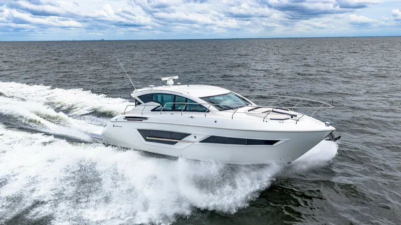 Slide: The Image of Cruisers Yachts Cantius 46 in Motion The 2019 Cruisers Yachts Cantius 46, named Serenity, slices through the water with elegance and power. Its sleek hull design and expansive windows reflect modern styling and offer panoramic views. The vessel's aerodynamic profile and robust construction e - 8141319