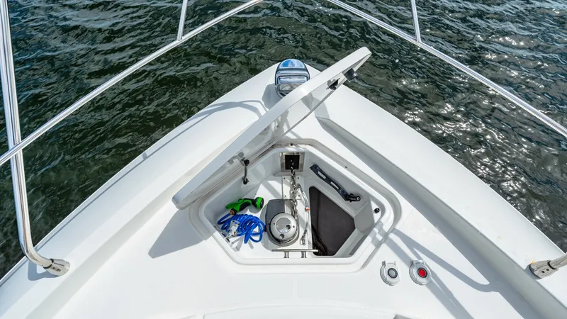 Slide: The Image of Foredeck Anchor Locker Access This image showcases the foredeck of the 2019 Serenity, a Cruisers Yachts Cantius 46, featuring an open anchor locker. The well-organized space includes a windlass, cleats, and storage for mooring lines, ensuring easy access and efficient anchoring operat - 8141276