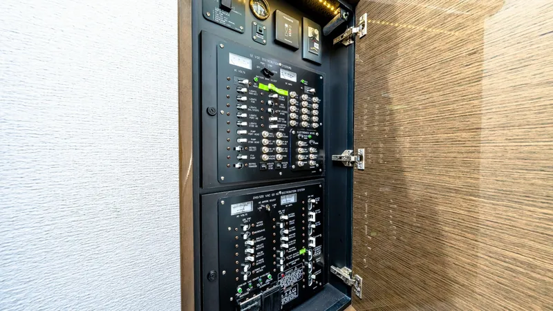 Slide: The Image of Electrical Control Panel This image showcases the sophisticated electrical control panel of the 2019 Cantius 46 by Cruisers Yachts. The panel is neatly organized with labeled switches and indicators, allowing for easy management of onboard electrical systems. The wood finish of t - 8141245