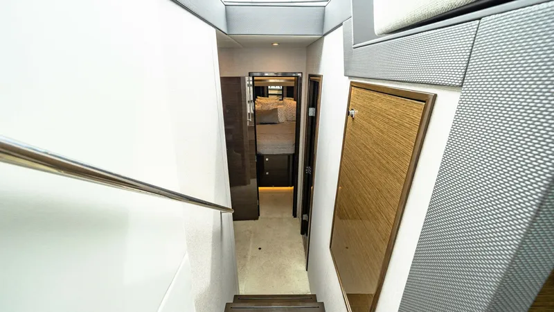 Slide: The Image of Stairway to Interior Cabins This image showcases the elegant stairway leading to the lower deck cabins of the 2019 Cruisers Yachts Cantius 46. The sleek design features polished wood steps and modern railings, creating a seamless transition from the upper deck. The corridor is well- - 8141244