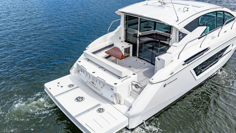 Slide: The Image of Aft Deck with Swim Platform The aft deck of the 2019 Cruisers Yachts Cantius 46, 'Serenity', features a spacious swim platform perfect for leisurely water activities. The sleek, open layout includes comfortable seating and easy access to the salon through sliding glass doors. This a - 8141302