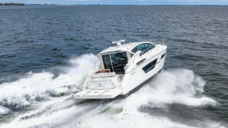 Slide: The Image of Aft View with Swim Platform The 2019 Cruisers Yachts Cantius 46, named Serenity, showcases a sleek aft view as it powers through the water. The expansive swim platform offers easy access to the sea, ideal for water activities. With its aerodynamic design and modern lines, this vesse - 8141307