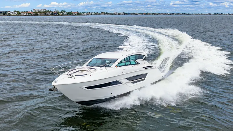 Slide: The Image of Dynamic Aerial View of Serenity The 2019 Serenity, a Cruisers Yachts Cantius 46, slices through the water effortlessly, showcasing its sleek, modern design. The vessel's sporty profile is complemented by expansive windows, offering panoramic views and abundant natural light. Its powerfu - 8141312