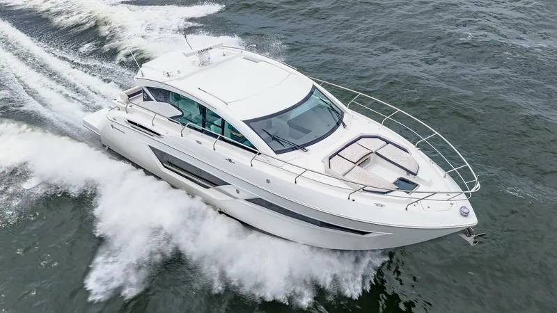 Slide: The Image of Aerial View of Cantius 46 Cruising The 2019 Cruisers Yachts Cantius 46, named Serenity, powers through the water with sleek, modern lines. This image showcases the spacious bow with comfortable sunpad seating, perfect for relaxation while underway. The elegant hardtop design and expansive - 8141327