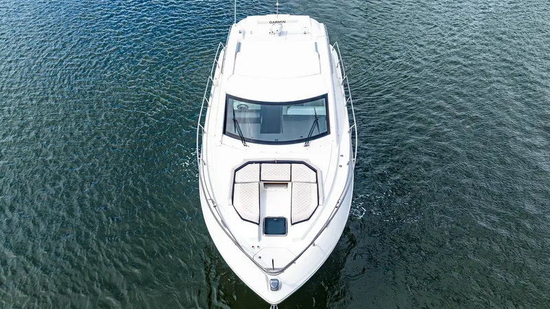 Slide: The Image of Aerial Bow View of Cantius 46 This image showcases the sleek bow of the 2019 Cantius 46 by Cruisers Yachts, named Serenity. The expansive deck space is perfect for sunbathing, featuring comfortable sun pads and an elegant, streamlined design. The large, wraparound windshield provides - 8141284