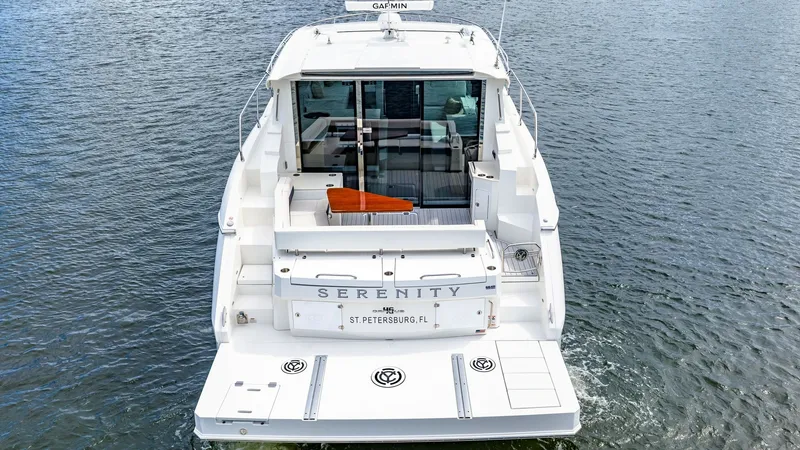 Slide: The Image of Aft Deck and Swim Platform The aft deck of the 2019 Cruisers Yachts Cantius 46, named 'Serenity', showcases a spacious swim platform perfect for easy water access. This area features elegant seating and a clear view through sliding glass doors leading to the interior. The sleek des - 8141292