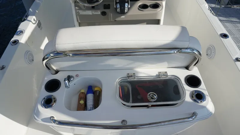 Slide: The Image of Cockpit with Helm Seating and Storage This image showcases the cockpit area of the 2016 Boston Whaler 270 Dauntless, featuring a comfortable helm seat with a cushioned backrest. The area includes convenient cup holders and a built-in sink, perfect for on-board refreshments. The design emphasi - 8087575