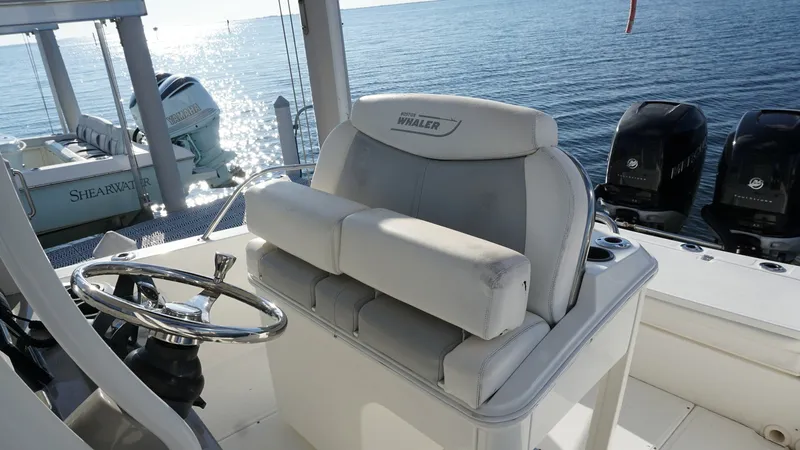 Slide: The Image of Helm Seating and Console View The helm of the 2016 Boston Whaler 270 Dauntless features a comfortable double bench seat with premium cushioning, ideal for long journeys. The sleek steering console is equipped with modern controls and displays, ensuring a seamless navigation experience - 8087565
