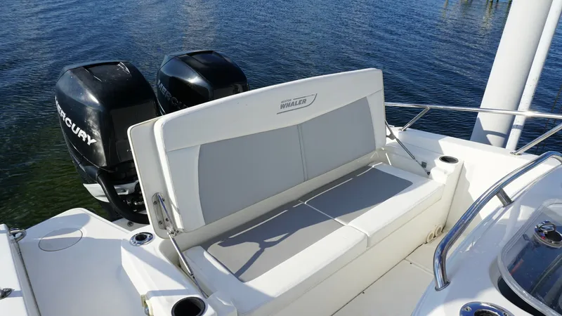 Slide: The Image of Aft Bench Seating with Engine View The 2016 Boston Whaler 270 Dauntless features a comfortable aft bench seating area, ideal for relaxing while cruising. The seating is flanked by easy-access cup holders and provides a clear view of the twin Mercury outboard engines, showcasing both power - 8087580