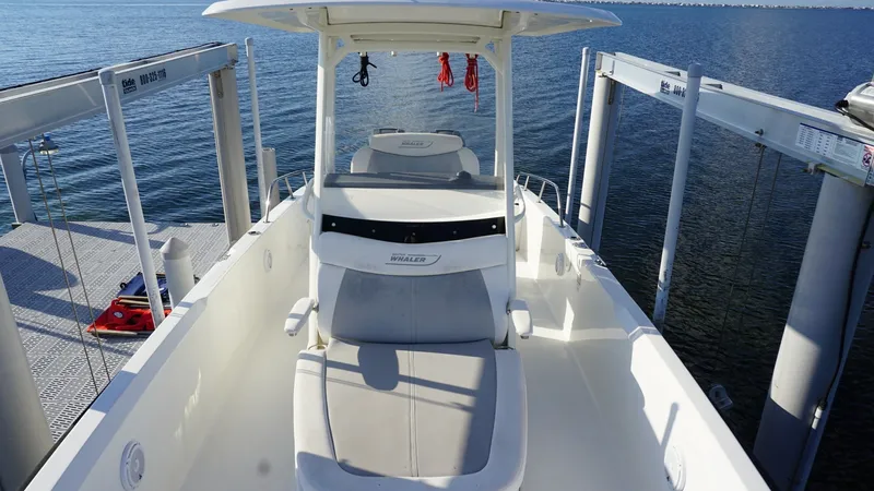 Slide: The Image of Bow Seating Area with Console The 2016 Boston Whaler 270 Dauntless features a versatile bow seating area, perfect for relaxation and socializing. The spacious layout includes comfortable cushioned seats and a sturdy T-top for shade. This setup is ideal for enjoying panoramic views whi - 8087573