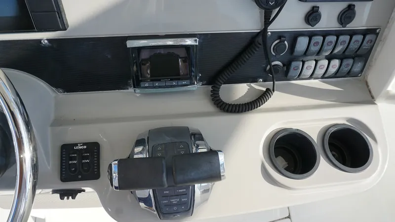 Slide: The Image of Helm Station with Controls The helm station of the 2016 Boston Whaler 270 Dauntless features an ergonomic design with modern control systems. The area includes a sleek throttle control, an array of functional switches, and conveniently placed cup holders. The layout ensures ease of - 8087569