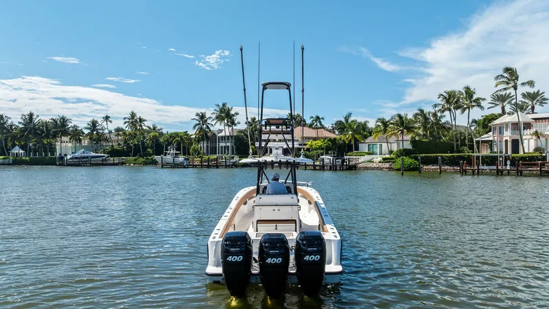 Slide: The Image of Aft View with Triple Outboard Engines This image showcases the powerful aft section of the 2024 SeaVee 340B, featuring triple 400 HP outboard engines. The clean, sleek design is complemented by a spacious deck area, ideal for fishing or leisure. The backdrop of a serene waterfront setting enh - 8398187