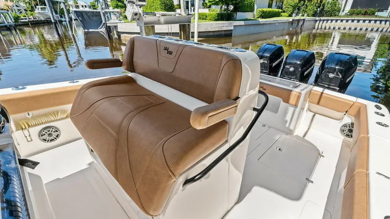 Slide: The Image of Helm Seating Area The helm seating area on the 2024 SeaVee 340B 'Gray Area' features plush, tan upholstery for maximum comfort during voyages. This ergonomic design includes bolstered seating and sturdy armrests, ensuring both style and functionality. The surrounding area - 8398197