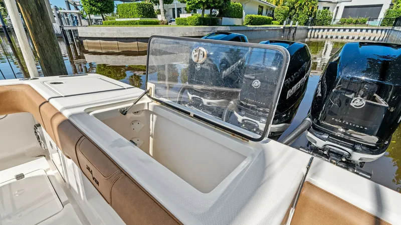 Slide: The Image of Aft Deck with Livewell The aft deck of the 2024 SeaVee 340B features a spacious livewell, perfect for keeping bait fresh during fishing trips. The area is complemented by comfortable seating with high-quality upholstery, ideal for relaxation. Twin outboard engines provide the v - 8398189