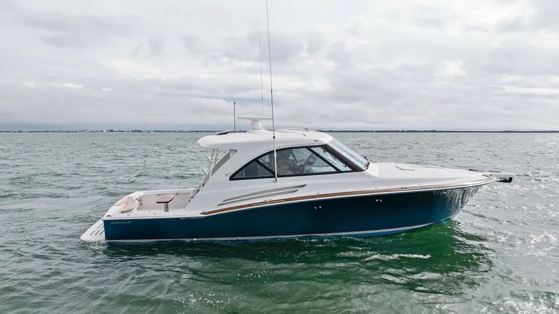 Slide: The Image of Starboard Profile of Hatteras GT45X The 2017 Hatteras GT45X showcases a sleek and powerful profile, emphasizing its robust construction and elegant design. The deep blue hull complements the streamlined superstructure, while large windows offer ample natural light to the interior. This vess - 8439518