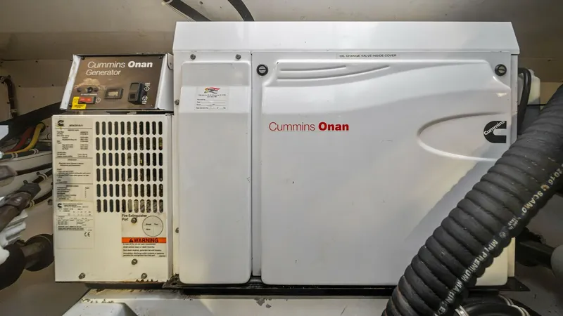 Slide: The Image of Engine Room with Cummins Onan Generator This image showcases the engine room of the 2017 Hatteras GT45X, featuring a Cummins Onan generator. The generator is a key component, providing reliable power for extended voyages. The clean and well-organized space highlights the vessel's commitment to - 8439562