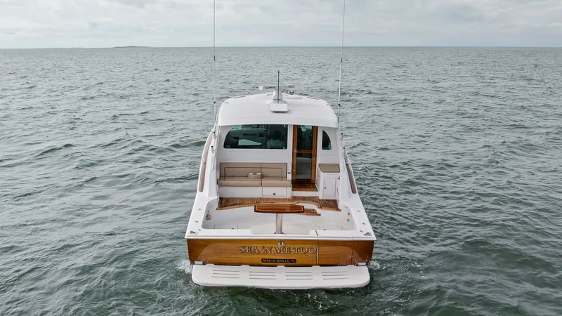 Slide: The Image of Aft Deck with Swim Platform The aft view of the 2017 Hatteras GT45X 'SEA'N ME TOO' showcases a spacious aft deck complemented by a sleek swim platform. The teak accents and ample seating area provide both functionality and comfort, perfect for social gatherings or relaxing after a d - 8439525