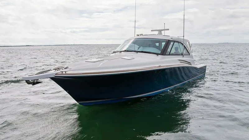 Slide: The Image of Dynamic Bow View of GT45X This striking image captures the sleek bow of the 2017 Hatteras GT45X, SEA'N ME TOO. The vessel's sharp hull lines and modern design elements are highlighted against the open water, showcasing its performance-oriented profile. The spacious foredeck and st - 8439523