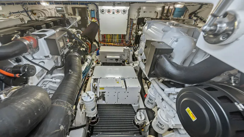 Slide: The Image of Engine Room with Twin Engines This image showcases the meticulously organized engine room of the 2017 Hatteras GT45X. Featuring twin engines, the space is designed for optimal performance and accessibility. The clean layout and advanced systems highlight the vessel's commitment to eng - 8439561