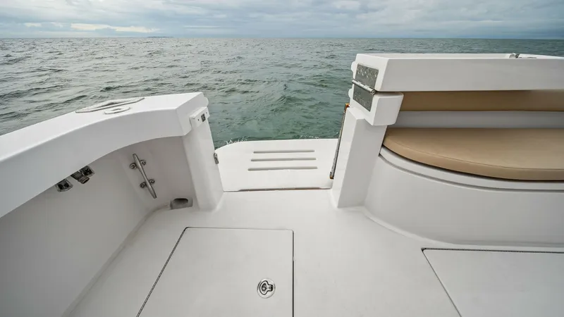 Slide: The Image of Aft Deck with Swim Platform This image showcases the aft deck of the 2017 Hatteras GT45X, featuring a spacious swim platform with easy access to the water. The clean, sleek design includes practical storage compartments and a comfortable seating area with a cushioned backrest. Ideal - 8439552