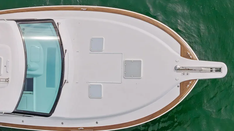 Slide: The Image of Bow View with Anchor System This aerial view showcases the sleek bow of the 2017 Hatteras GT45X, SEA'N ME TOO. The expansive foredeck features a clean layout with integrated anchor system, providing both functionality and style. The elegant teak trim accentuates the vessel's classic - 8439520