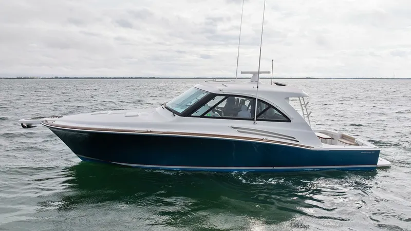 Slide: The Image of Profile View of Hatteras GT45X The 2017 Hatteras GT45X, SEA'N ME TOO, showcases its sleek and powerful profile against a serene water backdrop. The vessel's elegant lines and robust hull design highlight its superior craftsmanship and performance capabilities. The enclosed helm and spa - 8439522