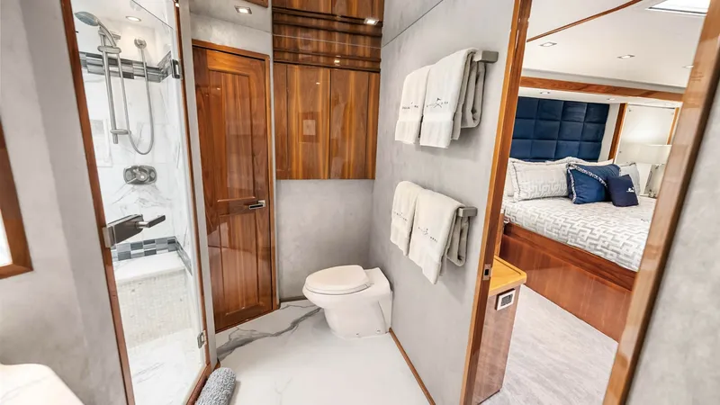 Slide: The Image of En-Suite Bathroom with Shower The en-suite bathroom features a sleek, modern design with a glass-enclosed shower and elegant fixtures. Rich wood accents complement the soft marble flooring, creating a luxurious atmosphere. This space seamlessly connects to the comfort of the adjacent - 8439616