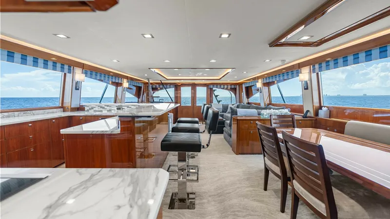 Slide: The Image of Spacious Salon with Panoramic Views The salon of the 2017 Viking 92 Enclosed Bridge offers an inviting, open layout with expansive windows that provide breathtaking ocean views. The space features elegant wood finishes, plush seating, and a sophisticated dining area, perfect for entertainin - 8439575