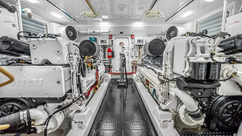 Slide: The Image of Engine Room with Twin Engines The engine room of the 2017 Viking 92 Enclosed Bridge showcases twin engines, meticulously arranged for optimal performance and efficiency. The space is well-lit and features non-slip flooring, ensuring safety and accessibility for regular maintenance. Sl - 8439628