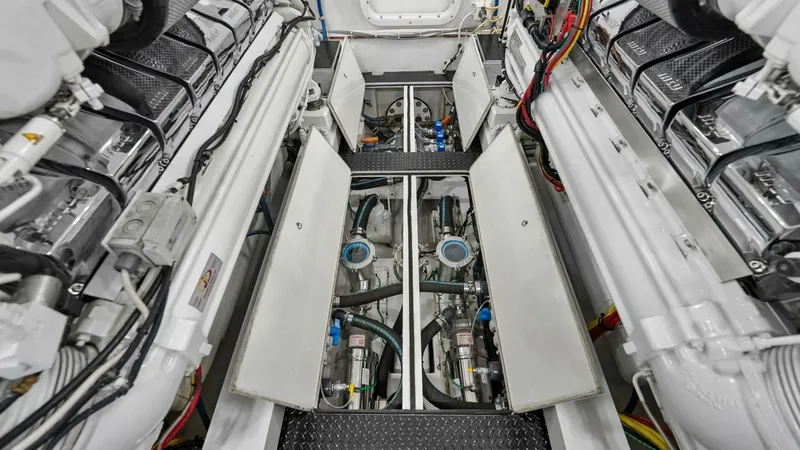Slide: The Image of Engine Room with Dual Engines The engine room of the 2017 Viking 92 Enclosed Bridge, 'Double Barrel,' showcases dual powerful engines meticulously arranged for optimal performance. The space is immaculately maintained, with neatly organized wiring and components ensuring easy access a - 8439635