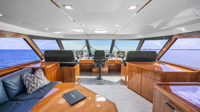 Slide: The Image of Spacious Enclosed Bridge Helm The enclosed bridge of the 2017 Viking 92 offers a commanding view with expansive windows and state-of-the-art navigation equipment. Luxuriously appointed with polished wood finishes and plush seating, this helm ensures comfort and style for the captain a - 8439586
