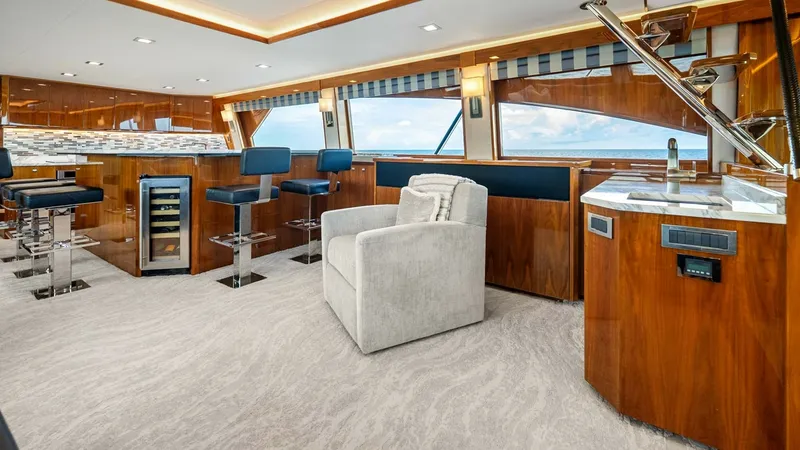 Slide: The Image of Enclosed Bridge Lounge and Bar Area The enclosed bridge of the 2017 Viking 92 Enclosed Bridge, Double Barrel, offers a luxurious lounge and bar area. Featuring plush seating, a built-in bar with high-top stools, and elegant wood finishes, this space is designed for both relaxation and enter - 8439584