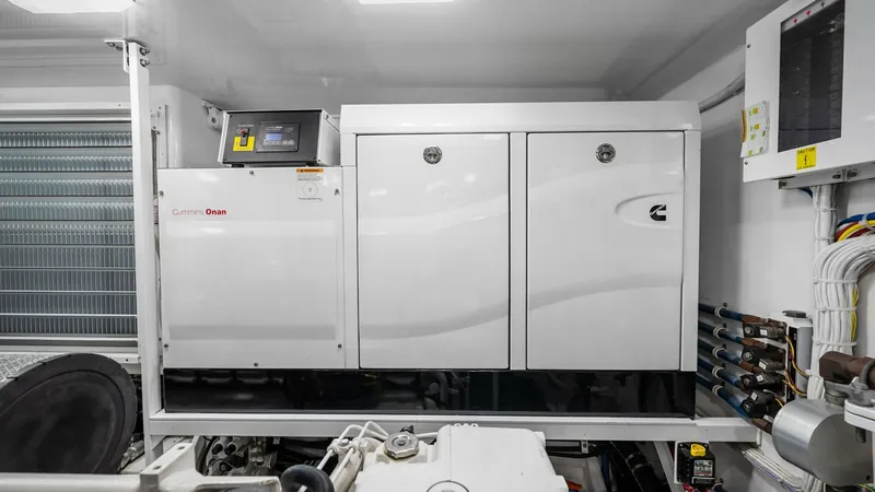 Slide: The Image of Engine Room with Cummins Generator The engine room of the 2017 Viking 92 Enclosed Bridge showcases a Cummins Onan generator, ensuring reliable power management for extended voyages. The space is meticulously organized, featuring advanced wiring systems and efficient layout for easy mainten - 8439629