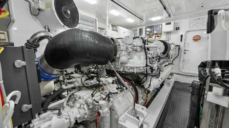 Slide: The Image of Engine Room with Twin Engines The engine room of the 2017 Viking 92 Enclosed Bridge showcases state-of-the-art twin engines, meticulously maintained for optimal performance. The space is well-lit with overhead lighting, ensuring visibility for maintenance and inspection. High-quality - 8439633