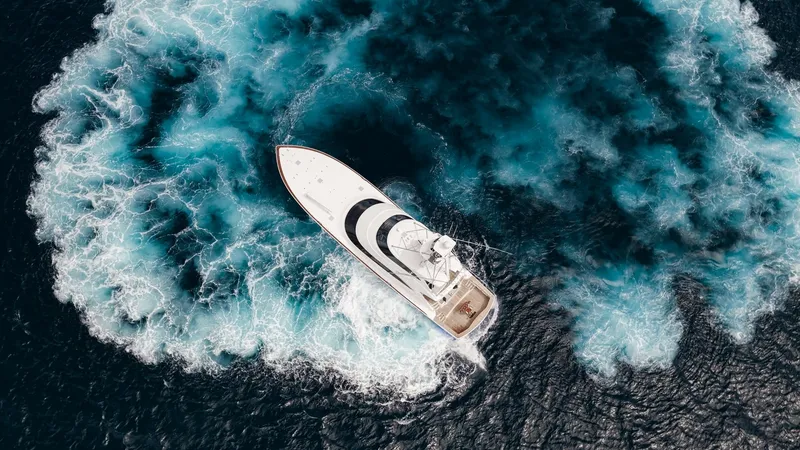 Slide: The Image of Aerial View of Viking 92 Enclosed Bridge This stunning aerial shot captures the Viking 92 Enclosed Bridge in action, slicing through the deep blue ocean. The vessel's sleek design and powerful performance are evident as it creates a dynamic wake, showcasing the strength and elegance of this 2017 - 8439649