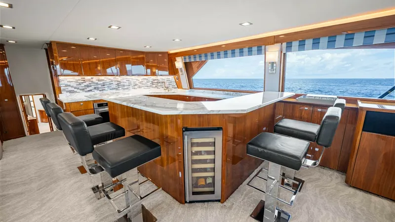 Slide: The Image of Enclosed Bridge Helm and Bar Area This elegant enclosed bridge features a sleek bar area with luxurious high-backed stools and a modern wine cooler. The polished wood finishes and expansive windows provide a stunning panoramic view of the ocean. The space is designed for both comfort and - 8439578