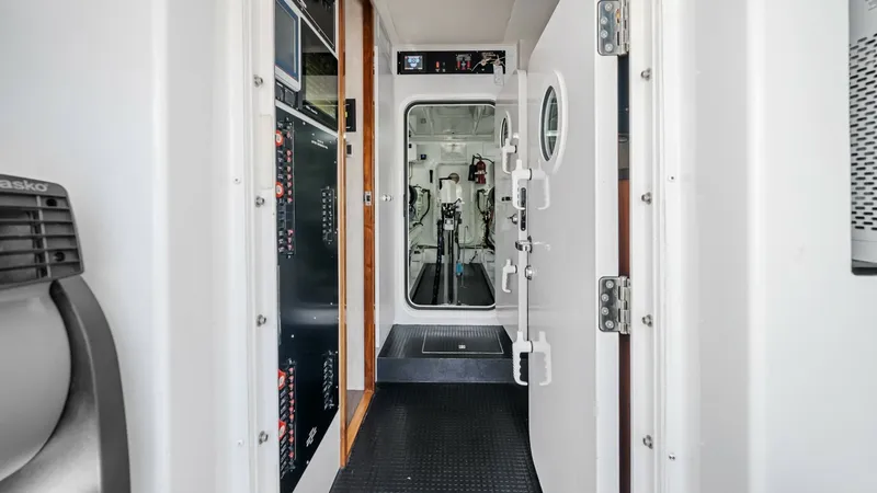 Slide: The Image of Engine Room Access Corridor This image showcases the access corridor leading to the engine room of the 2017 Viking 92 Enclosed Bridge. The hallway features robust door fittings and a non-slip floor, ensuring safety and durability. The corridor's clean design and well-organized layou - 8439627