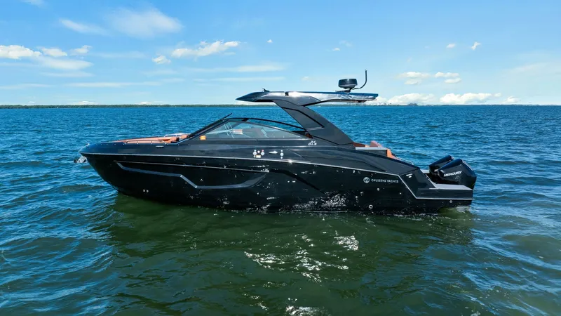 Slide: The Image of Starboard Profile of 2022 Cruisers 34 GLS This image showcases the sleek starboard profile of the 2022 Cruisers Yachts 34 GLS. The modern design features a striking black hull complemented by a streamlined hardtop, creating an elegant and sporty appearance. Outboard engines promise powerful perfo - 8398544