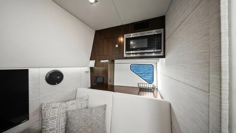 Slide: The Image of Modern Galley with Microwave and Seating This sleek galley area features a convenient built-in microwave, offering practicality and style for on-board dining. The space is complemented by a plush seating arrangement, adorned with patterned cushions for added comfort. A well-placed window provide - 8398535