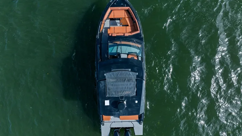 Slide: The Image of Aerial View of Cruisers Yachts 34 GLS This aerial shot showcases the sleek design and layout of the 2022 Cruisers Yachts 34 GLS. The spacious deck features ample seating with luxurious orange upholstery, perfect for entertaining or relaxing. The twin engines at the stern promise powerful perf - 8398538