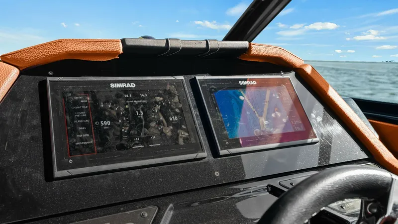 Slide: The Image of Helm Station with Dual Displays The 2022 Cruisers Yachts 34 GLS features a modern helm station equipped with dual Simrad displays, offering advanced navigation and system monitoring capabilities. The ergonomic design includes a comfortable steering wheel and sleek dashboard, ensuring ea - 8398517