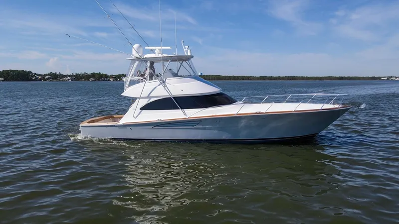 Slide: The Image of Side Profile of Flybridge Yacht The 2024 Viking 54 Convertible 'Nomad' is showcased cruising gracefully on open waters. Its sleek hull design and modern flybridge offer an impressive blend of performance and style. The spacious deck and premium finishes highlight the vessel's luxurious - 8439839