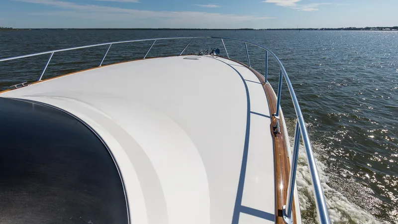 Slide: The Image of Sleek Forward Deck with Railings Experience the expansive forward deck of the 2024 Viking 54 Convertible, showcasing a sleek, modern design with polished stainless steel railings. The smooth, wide surface offers unobstructed views, perfect for enjoying scenic cruising. The high-quality f - 8439813