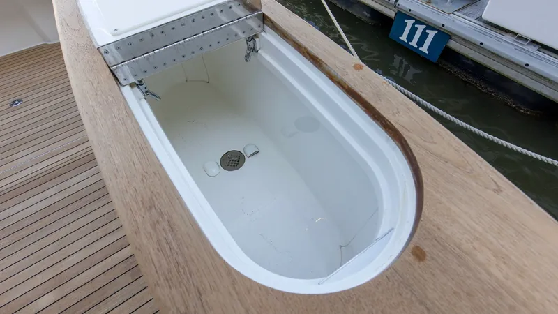 Slide: The Image of Built-In Cockpit Fish Box This image showcases the spacious built-in fish box located in the cockpit of the 2024 Viking 54 Convertible. Constructed with durable materials, it provides ample storage for your catch, making it ideal for avid anglers. The sleek teak decking surroundin - 8439811