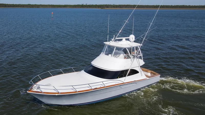 Slide: The Image of Aerial View of Viking 54 Convertible This image captures the sleek design of the 2024 Viking 54 Convertible, highlighting its spacious flybridge and classic lines. The elegant teak accents along the bow and cockpit add a touch of luxury, while the sturdy railings ensure safety and functional - 8439842